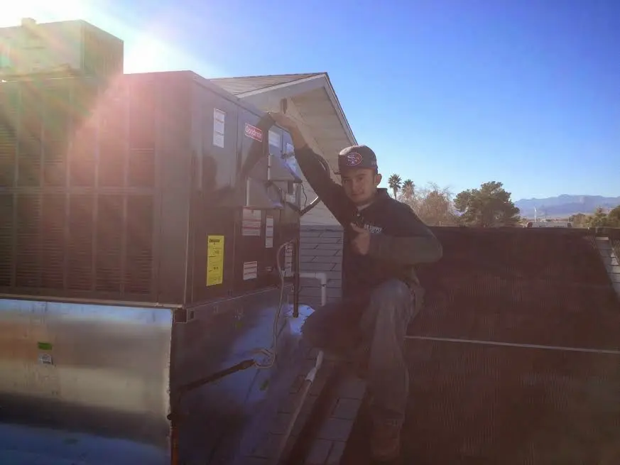 HVAC technician performing AC Tune-Up on a rooftop unit in Sea Cliff